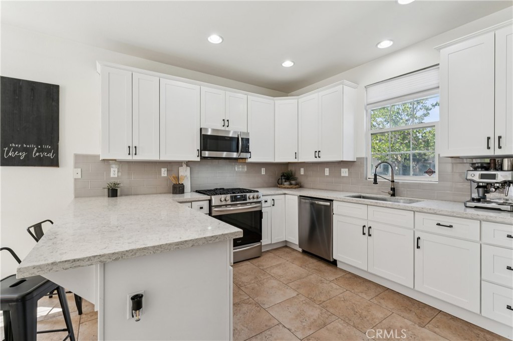 4155 Windspring Street Corona, CA 92883 - Photo 9 of 38 a kitchen with cabinets appliances a sink and a window