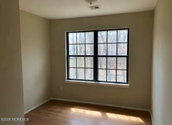 a view of a big room with wooden floor and windows