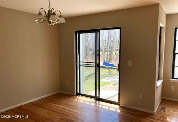 a view of a big room with wooden floor and windows