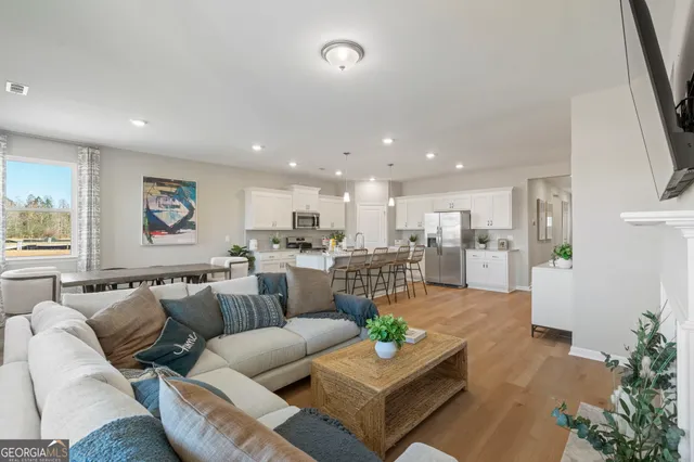 a living room with furniture kitchen and a table
