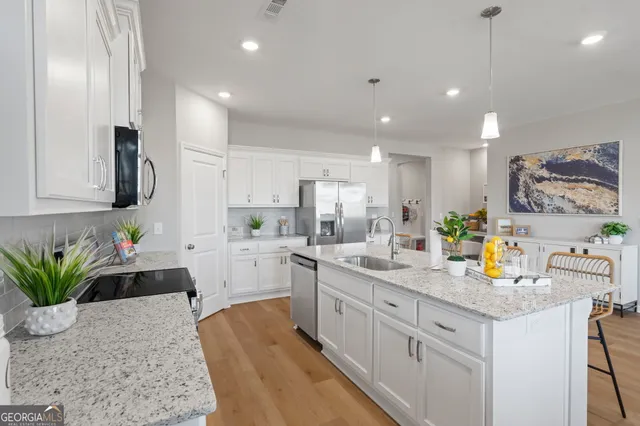 a kitchen with white cabinets and sink