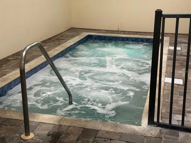 a swimming pool with outdoor seating and trees