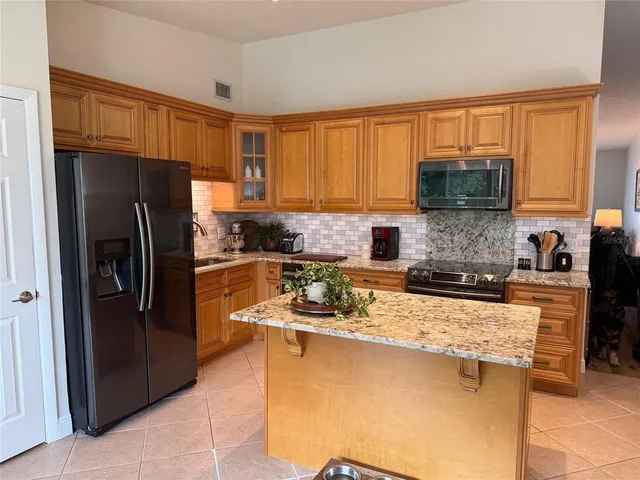 a kitchen with stainless steel appliances granite countertop a refrigerator stove top oven a sink and dishwasher