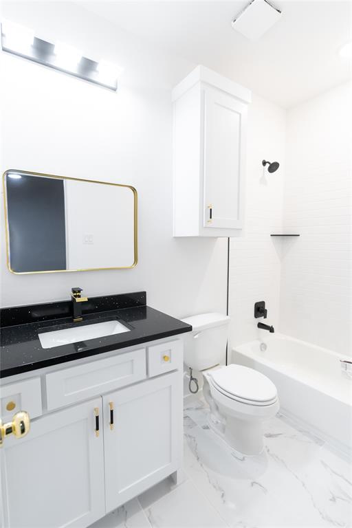 839 Southwest 7th Street Cooper, TX 75432 - Photo 6 of 21 Bathroom with tub / shower combination, toilet, vanity, and marble finish floor