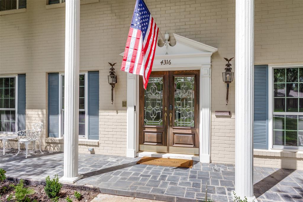 4316 Springbranch Drive Benbrook, TX 76116 - Photo 4 of 39 Front entry featuring double wood doors with decorative glass panels, a pediment above, and two wall-mounted lanterns