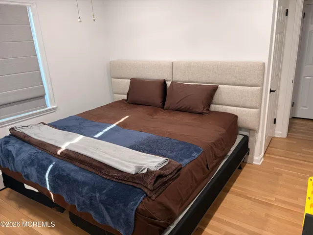 a bedroom with a bed and wooden floor