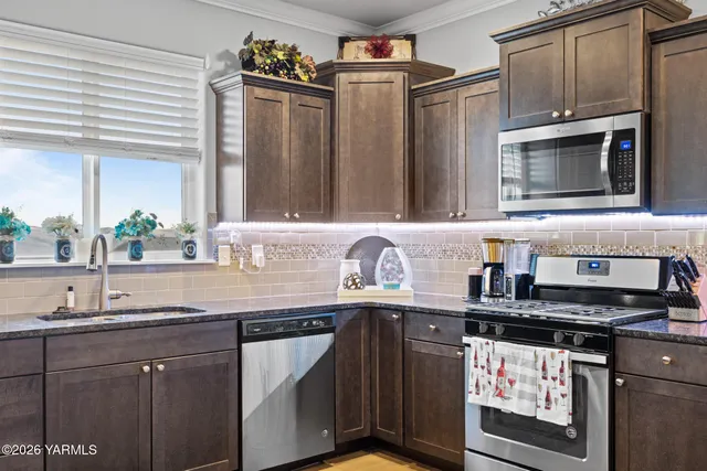 a kitchen with stainless steel appliances granite countertop a sink stove and microwave