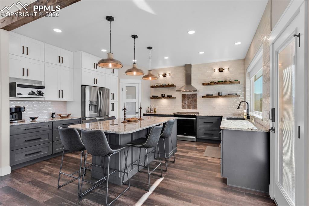 228 Freek Ranch Road Canon City, CO 81212 - Photo 20 of 50 a kitchen with stainless steel appliances kitchen island granite countertop a table chairs and a refrigerator