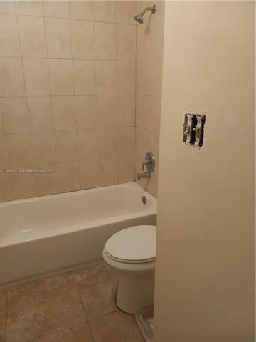 a bathroom with a toilet and a bath tub