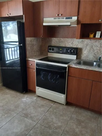 a stove top oven sitting inside of a kitchen