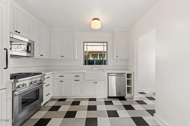 a kitchen with a stove a sink and a window