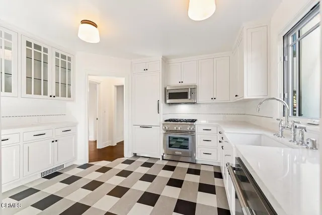 a kitchen with granite countertop a sink a stove and a refrigerator