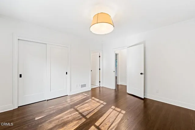 a view of a room with wooden floor and white walls