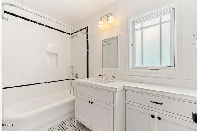 a bathroom with a bathtub a shower a sink and a window