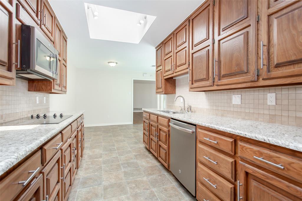 6807 Anglebluff Circle Dallas, TX 75248 - Photo 16 of 28 a kitchen with stainless steel appliances granite countertop a sink and cabinets