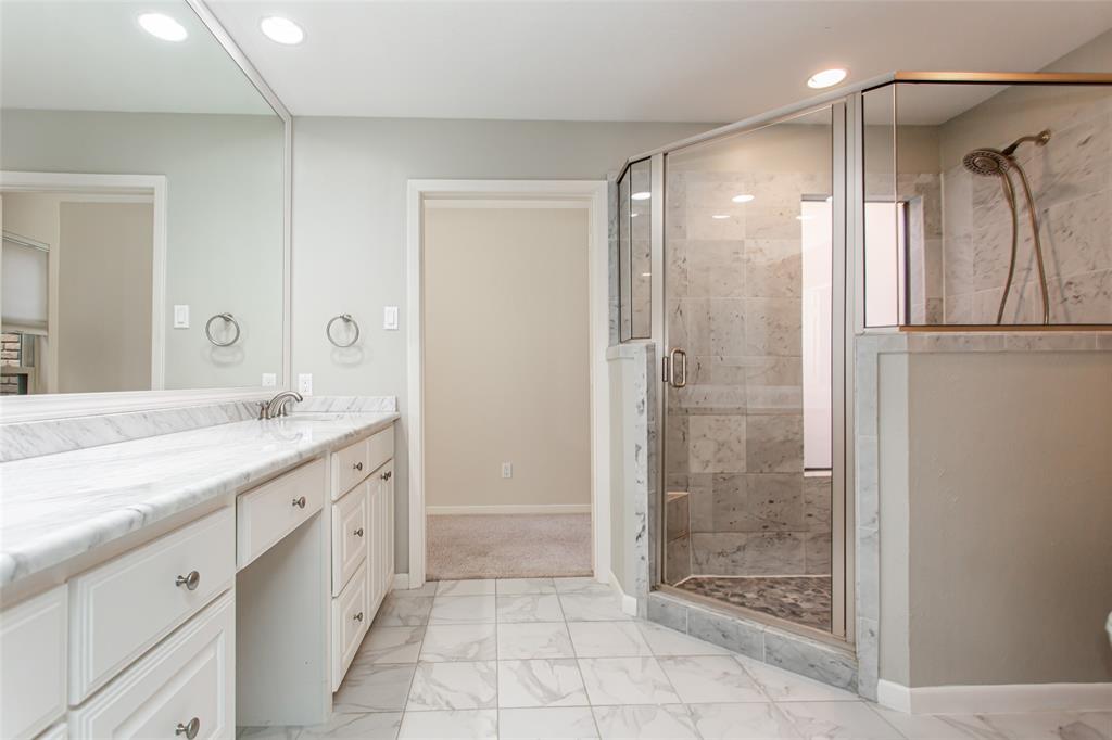 6807 Anglebluff Circle Dallas, TX 75248 - Photo 25 of 28 a spacious bathroom with a shower sink and mirror