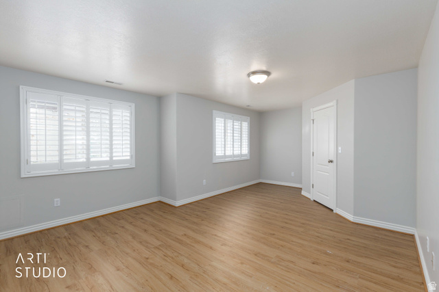 2327 Bluff Ridge Drive Syracuse, UT 84075 - Photo 37 of 66 Spacious room featuring wood-finish flooring, light gray walls, white baseboards, and two windows with plantation shutters