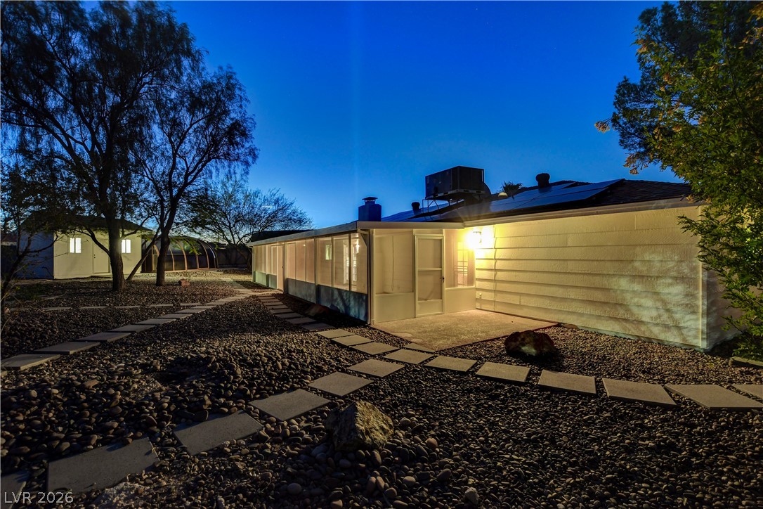 7631 Bermuda Road Las Vegas, NV 89123 - Photo 64 of 64 A private yard with stepping stones creates a serene outdoor retreat at twilight.