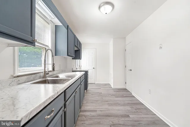 a room with kitchen island a sink dishwasher and wooden floor