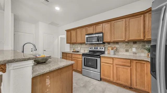 a kitchen with stainless steel appliances granite countertop a stove a sink dishwasher and a microwave