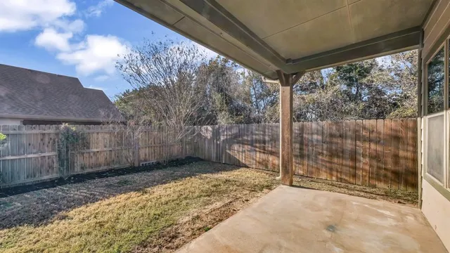 a view of a backyard with wooden fence