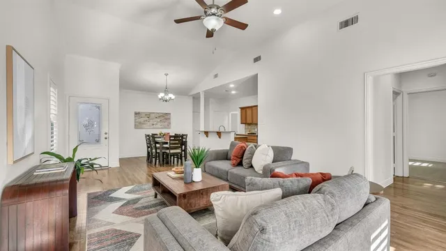 a living room with furniture and a view of kitchen