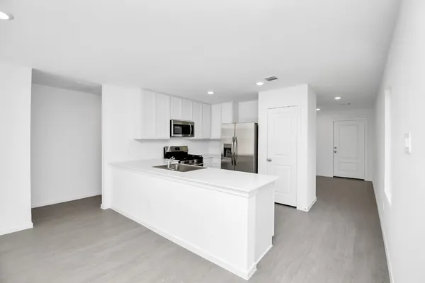 a kitchen with stainless steel appliances a refrigerator and a stove top oven