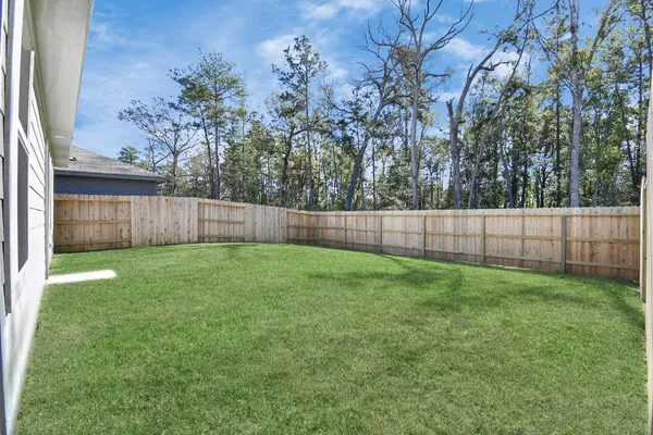 a view of yard with green space and wooden fence