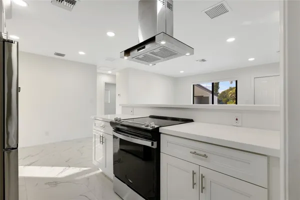 a kitchen with stainless steel appliances a refrigerator and a stove top oven