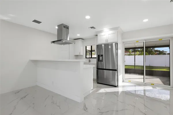 a kitchen with refrigerator a counter top space and stainless steel appliances