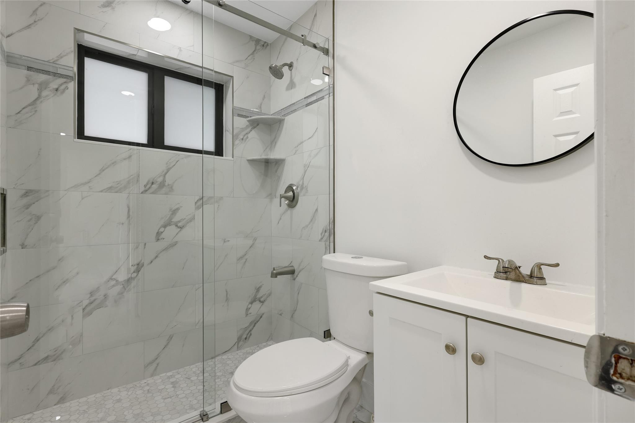 6374 Southwest 2nd Street Margate, FL 33068 - Photo 19 of 28 a bathroom with a sink a mirror a toilet and a shower