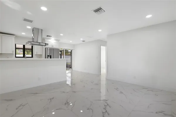 a view of a kitchen with refrigerator and window