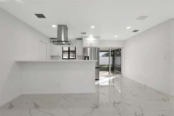 a kitchen with stainless steel appliances a refrigerator and a stove top oven