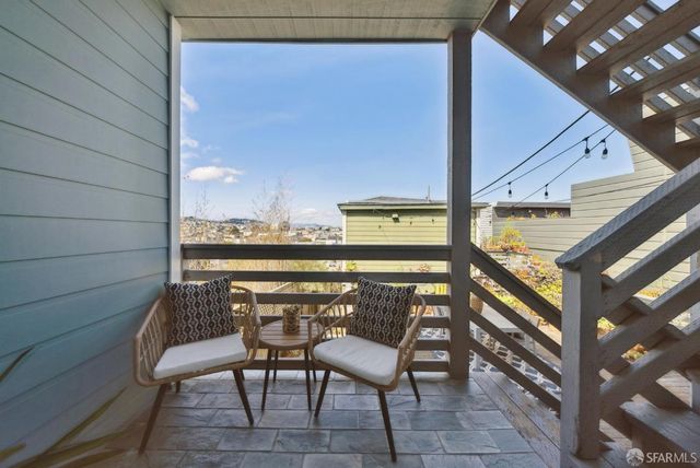 a view of a chairs and table in the balcony