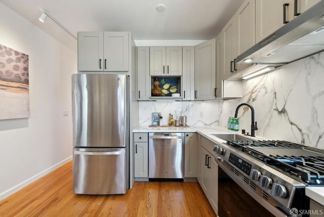 a kitchen with stainless steel appliances granite countertop a stove a sink and a microwave