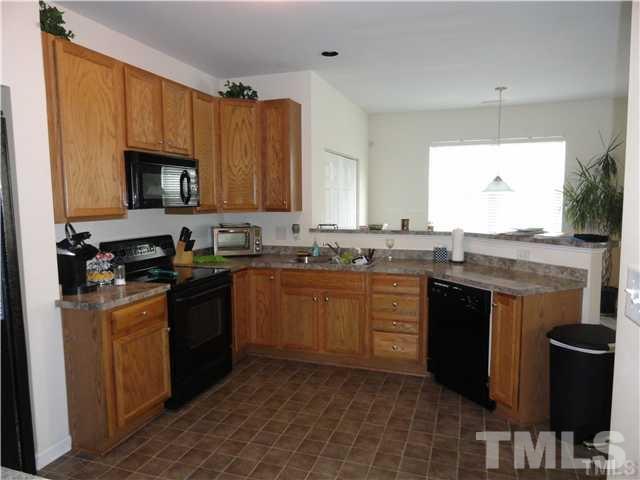 4705 Alenja Lane Raleigh, NC 27616 - Photo 4 of 15 a kitchen with granite countertop a sink stove and cabinets