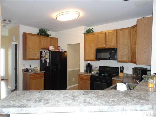 4705 Alenja Lane Raleigh, NC 27616 - Photo 6 of 15 a kitchen with stainless steel appliances granite countertop a refrigerator stove top oven and sink