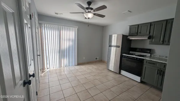 an empty room with windows and fan