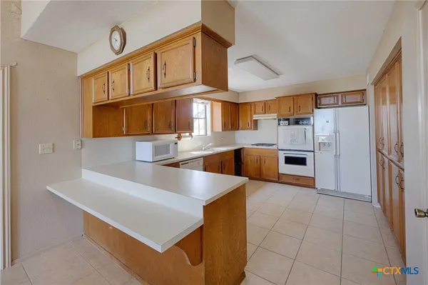 a kitchen with stainless steel appliances granite countertop a sink a stove and a refrigerator
