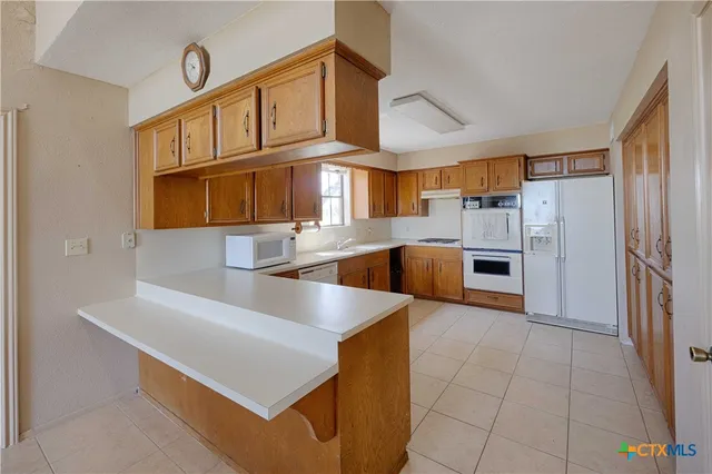 a kitchen with stainless steel appliances granite countertop a sink a stove and a refrigerator