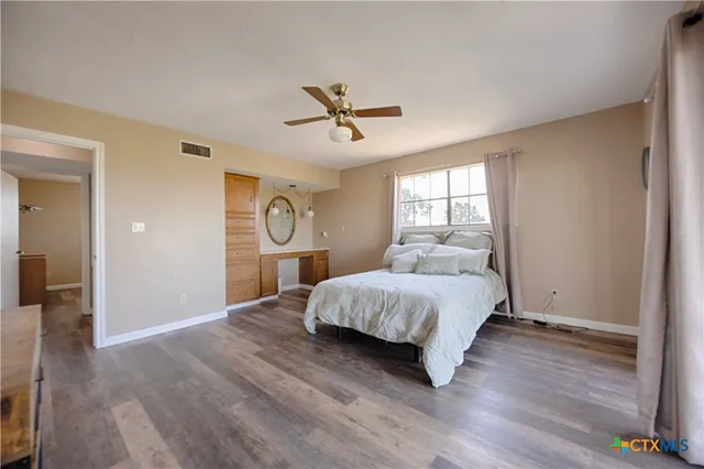 a spacious bedroom with a bed chandelier and a window