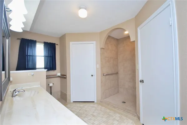 a bathroom with a sink a toilet and shower