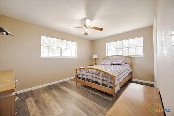 a bedroom with a bed lamp closet and windows