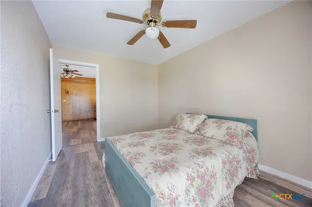 a bedroom with a bed and a ceiling fan