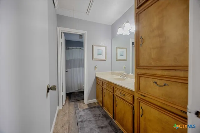 a bathroom with a granite countertop sink a mirror and a shower
