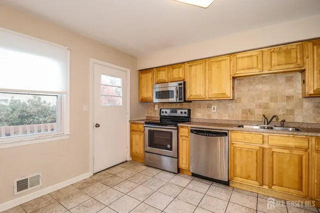 a kitchen with stainless steel appliances granite countertop a stove a sink and a microwave