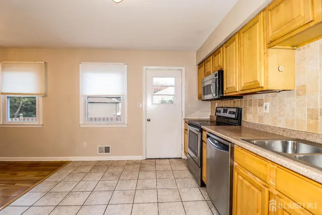 a kitchen with stainless steel appliances granite countertop a sink and a stove