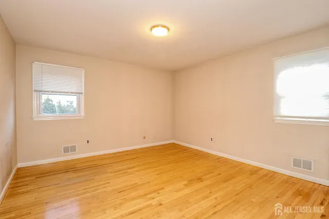 a view of a room with wooden floor and windows