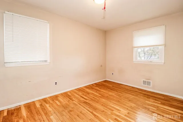 a view of a room with wooden floor and a window