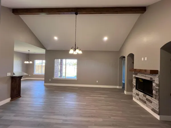 an empty room with wooden floor and fireplace